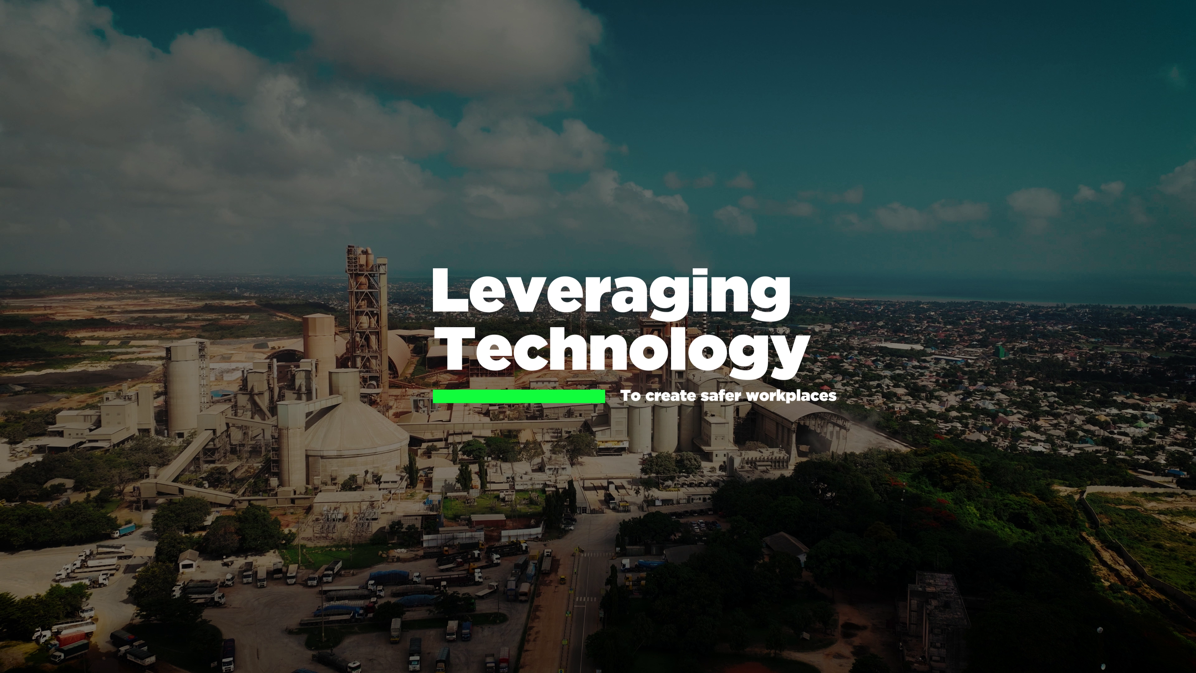 An industrial site with a cement plant surrounded by greenery and urban areas, featuring the text "Leveraging Technology" prominently overlaid.