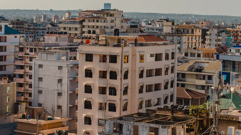 A cityscape featuring mid-rise residential and commercial buildings under a clear sky.